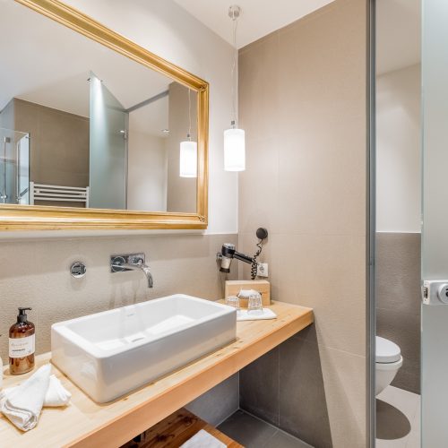 Modernes Badezimmer mit Holz und eleganter Beleuchtung.
