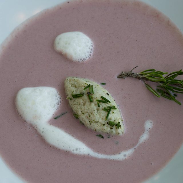 Cremefarbene Suppe mit Kräutern und Schaum