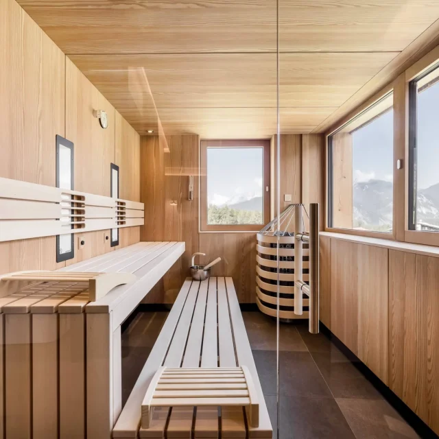 Moderne Sauna mit Holzinterieur und Bergblick.