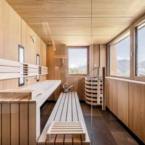Moderne Sauna mit Holzinterieur und Bergblick.