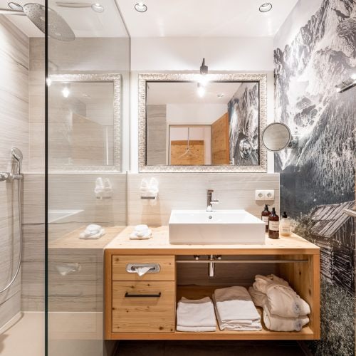 Modernes Badezimmer mit Dusche und Holzregalen.