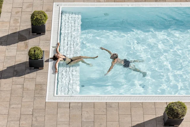 Menschen im Pool genießen den Sommer.