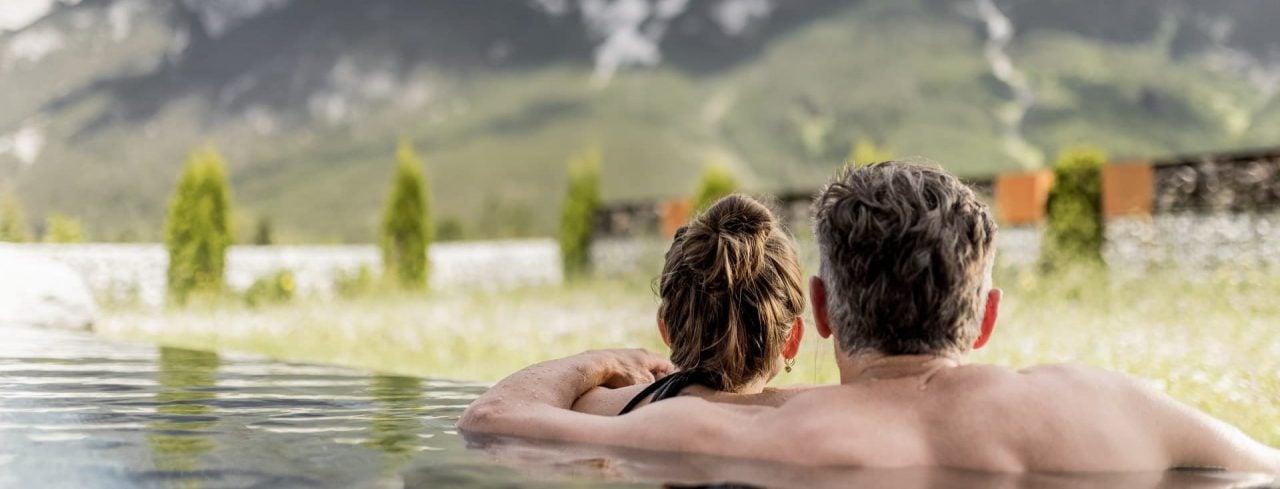 Paar entspannt in einem Infinity-Pool in der Natur.