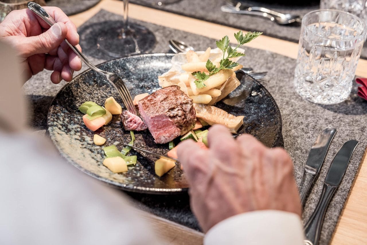 Nahaufnahme eines Tellers mit Fleisch und Gemüse.