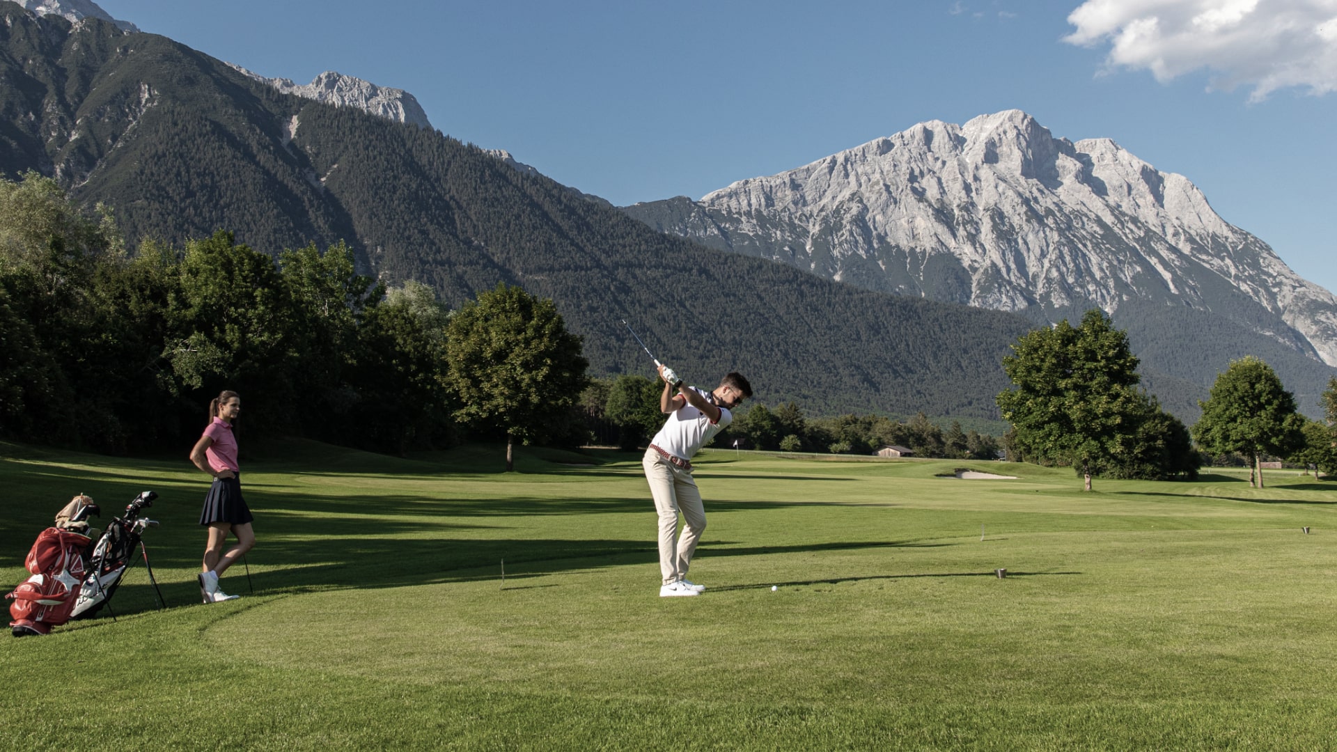 Golfspieler mit Berglandschaft im Hintergrund.