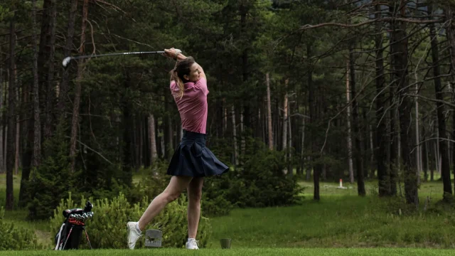 Frau spielt Golf im Wald