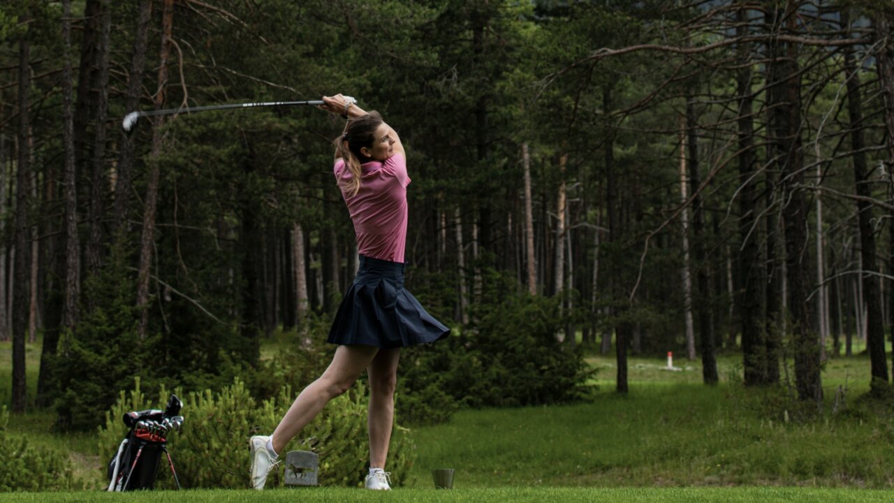 Frau spielt Golf im Wald