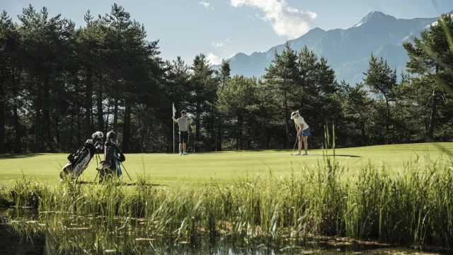 Golfspielende Personen in malerischer Landschaft