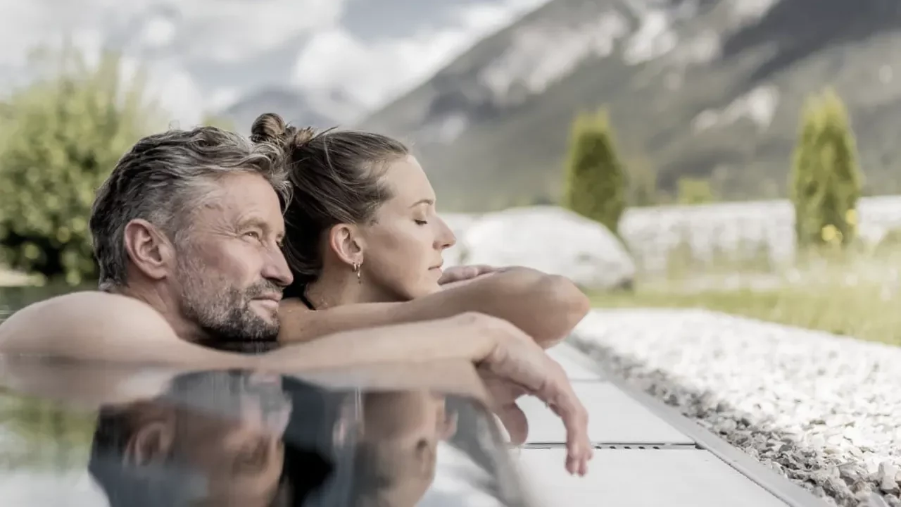 Entspannendes Paar am Pool mit Bergblick.