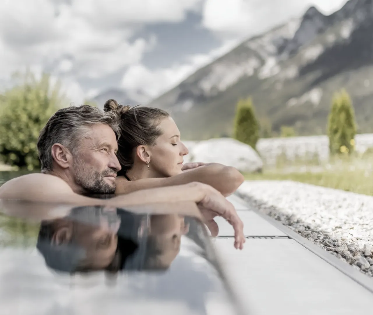Entspannendes Paar am Pool mit Bergblick.