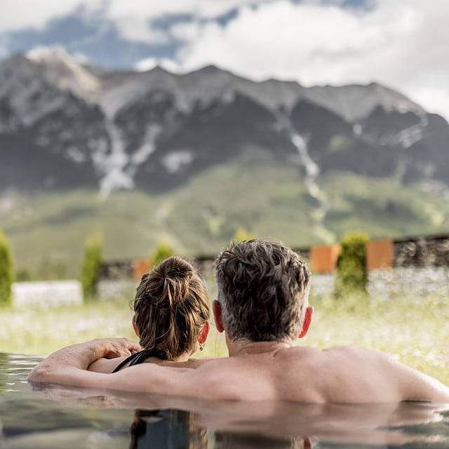 Paar entspannt in einem Pool mit Bergblick.