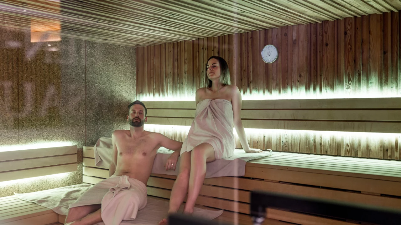 Entspanntes Paar in der Sauna sitzt gemeinsam.