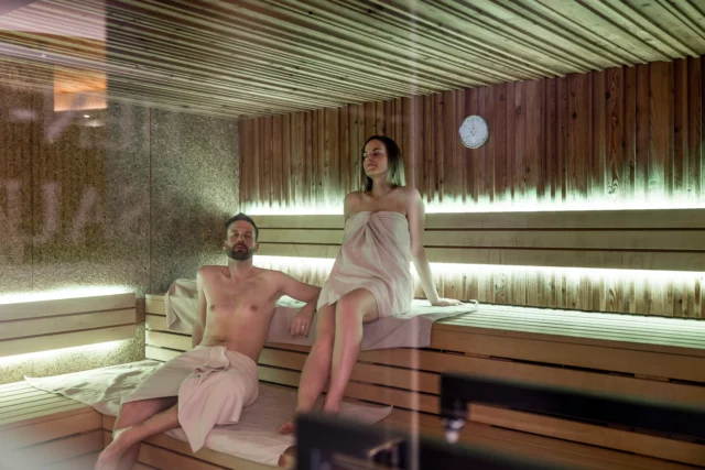 Entspanntes Paar in der Sauna sitzt gemeinsam.