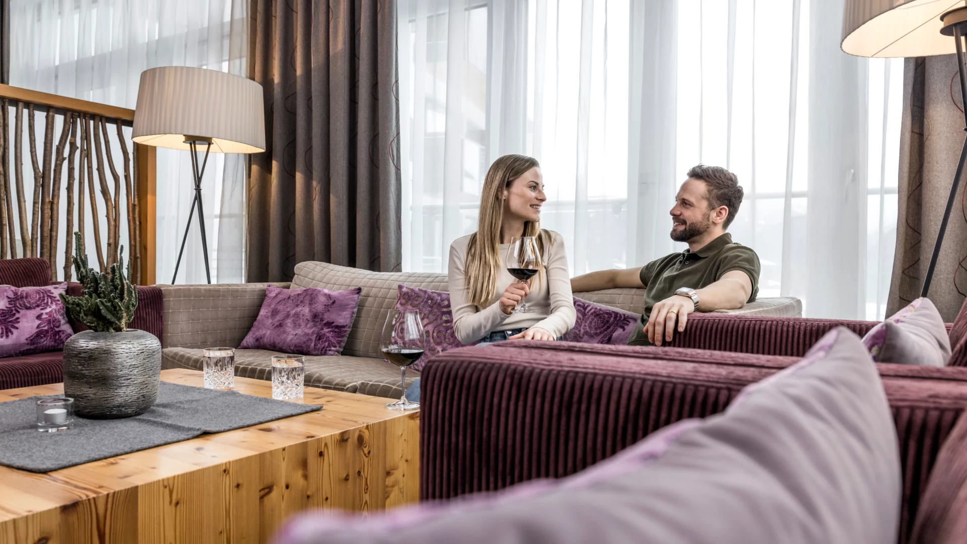 Paar genießt Wein in modernem Wohnzimmer.
