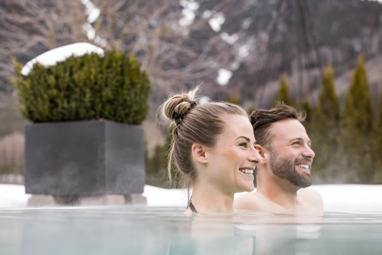 Lächelnde Menschen in einem warmen Wasserbecken.
