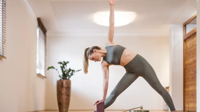 Frau übt Yoga in einem ruhigen Raum.