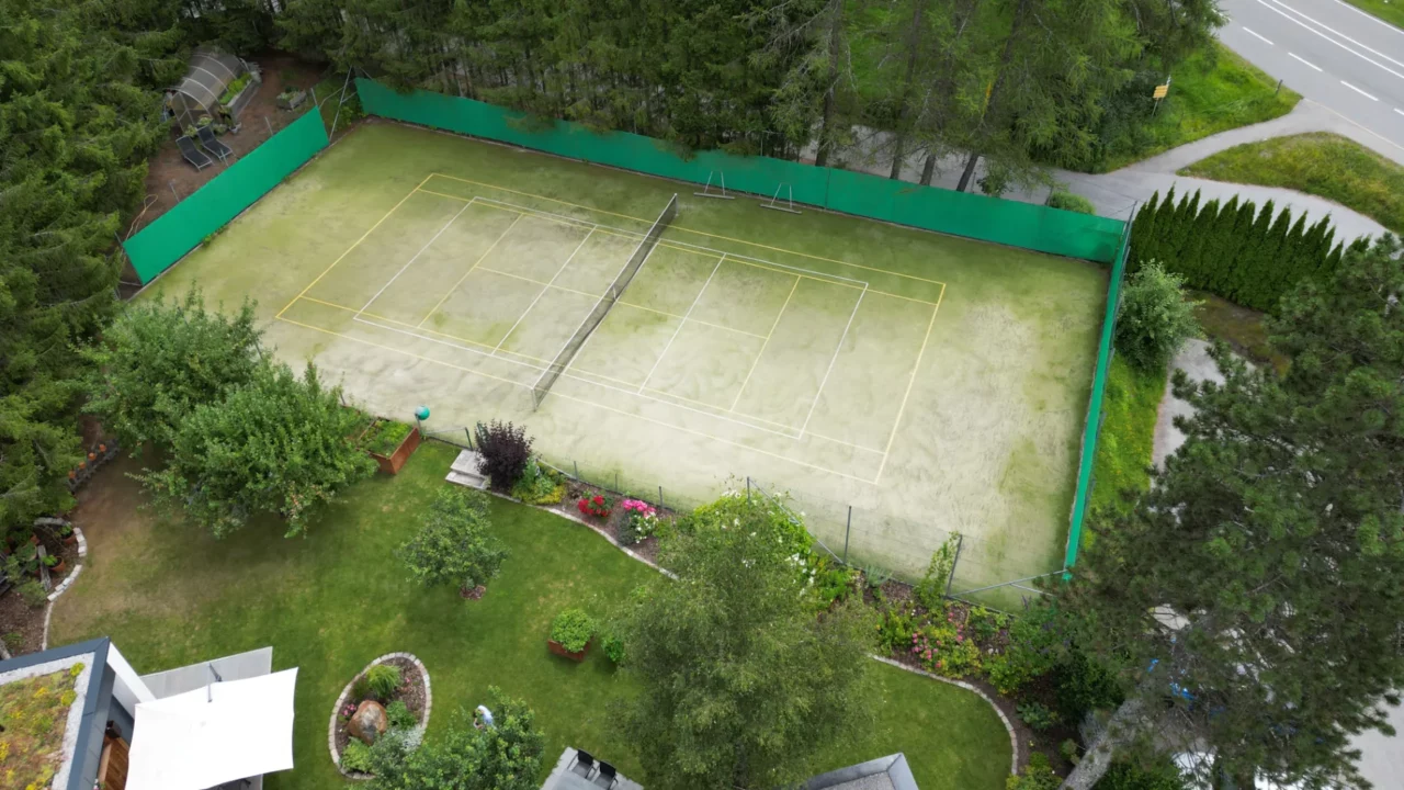 Tenniscourt umgeben von grüner Landschaft